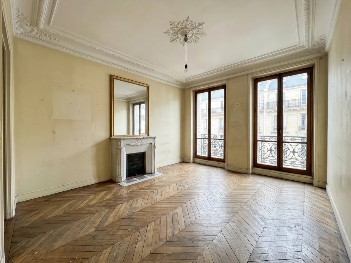 Salon haussmannien vide avant home staging virtuel : parquet point de Hongrie, cheminée en marbre, murs défraîchis
